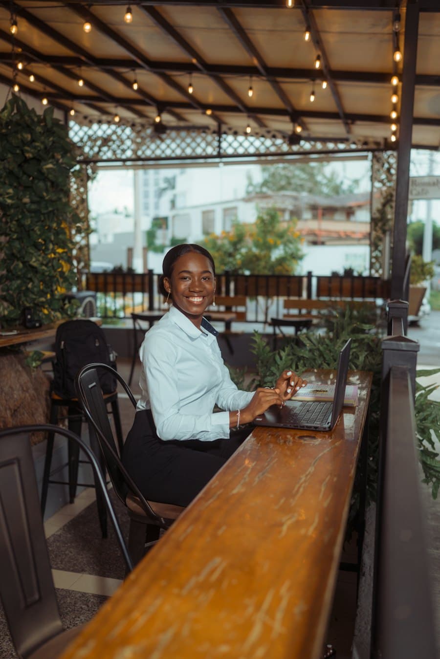 Cafe owner smiling at a laptop on her patio