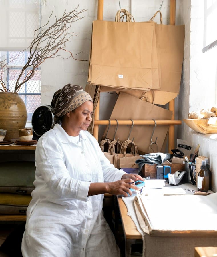 Shop owner packing an online order at her workbench